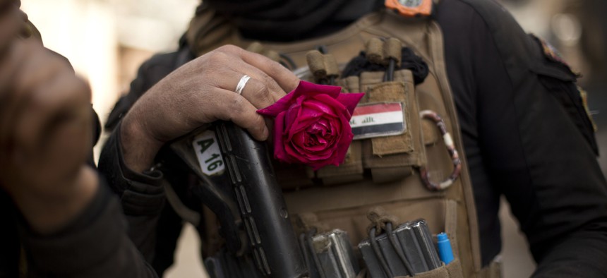 An Iraqi special forces soldier wears a rose in his body armor as troops move from the Yarmouk neighborhood to take another district from Islamic State militant control in Mosul, Iraq, Wednesday, April 12, 2017. 