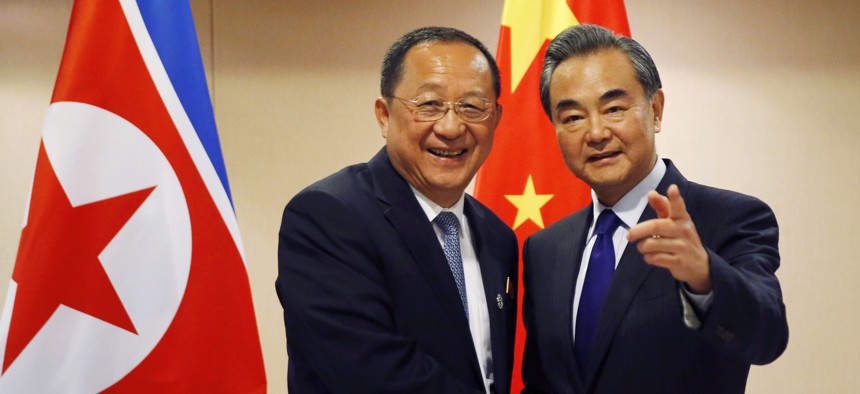 North Korean Foreign Minister Ri Yong Ho, left, is greeted by his Chinese counterpart Wang Yi prior to their bilateral meeting in the sidelines of the 50th ASEAN Foreign Ministers' Meeting August 6.