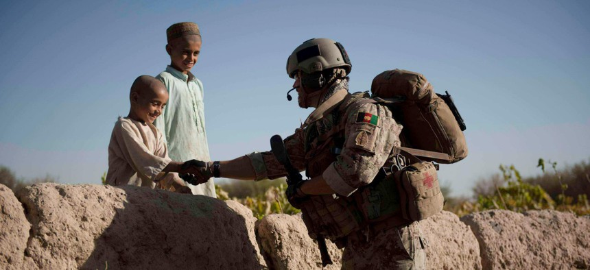 A U.S. Army Green Beret greets Afghan children during a foot patrol in Kandahar province, September 2010.