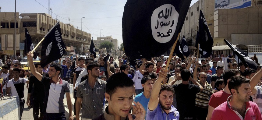 Demonstrators chant pro-ISIS slogans as they carry the group's flags in front of the provincial government headquarters in Mosul in 2014.