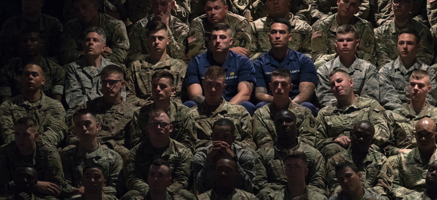 Members of the military in the audience look to President Donald Trump as he speaks at Fort Myer about his administration's policy for Afghanistan.