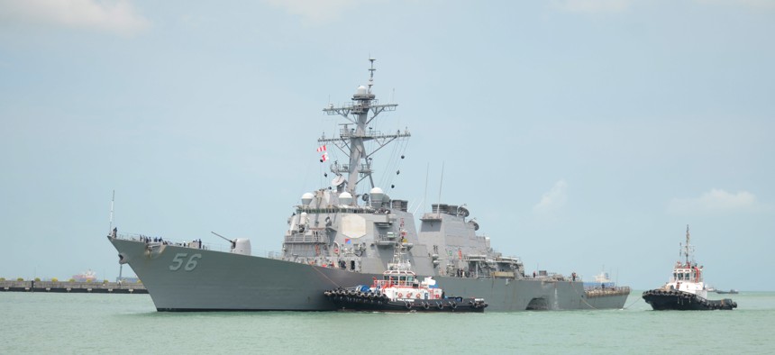 Tugboats from Singapore assist the Guided-missile destroyer USS John S. McCain as it steers towards Changi Naval Base, Republic of Singapore following a collision with the merchant vessel. 