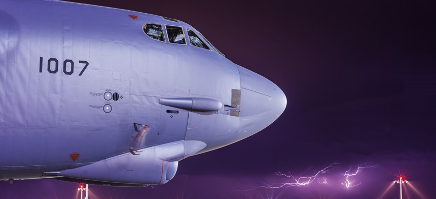 Lightning strikes behind a B-52H Stratofortress at Minot Air Force Base, N.D.