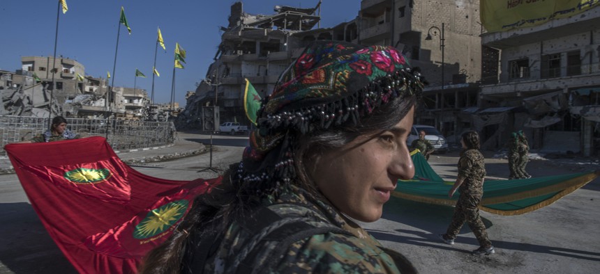 In this Thursday, Oct. 19, 2017 photo, fighters from the Women's Protection Units, or YPJ, hold a celebration in Paradise Square in Raqqa, Syria.