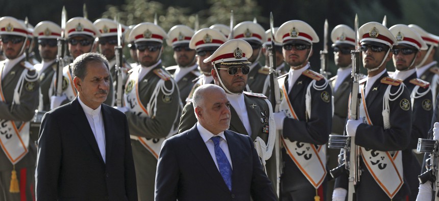 Iraqi Prime Minister Haider al-Abadi, center, reviews an honor guard while accompanied by Iranian Senior Vice-President Eshaq Jahangiri, at the Saadabad Palace in Tehran, Iran, Oct. 26, 2017.