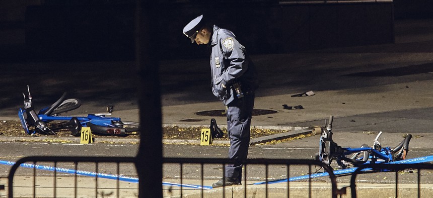 A police officer stands guard next to bicycles on a bike path at the crime scene after a motorist Tuesday drove onto the path, striking and killing several people, in Manhattan, Nov. 1. 