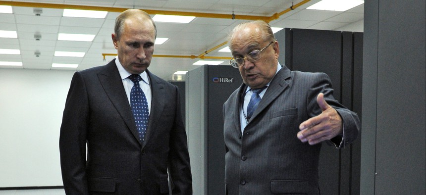 Russian President Vladimir Putin listens to an explanation of the head of Moscow's State University Viktor Sadovnichy, right, during a visit to laboratory, where super computer Lomonosov is placed, at the university on Thursday, Oct. 30, 2014