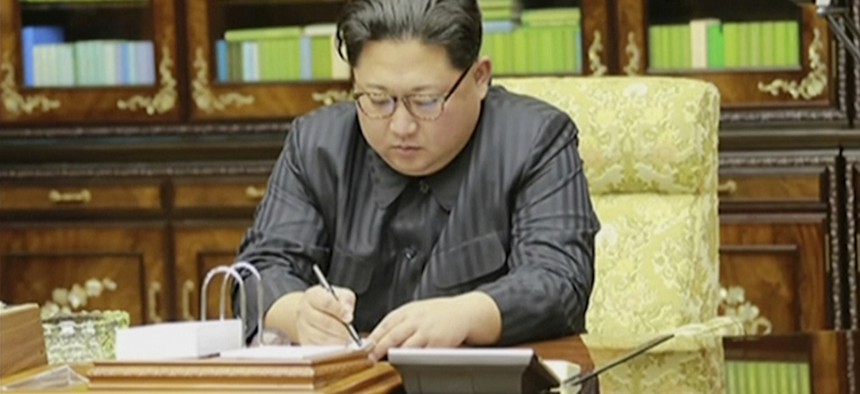 North Korea's leader Kim Jong Un signs what is said to be a document on Nov. 28, 2017, authorizing a missile test.