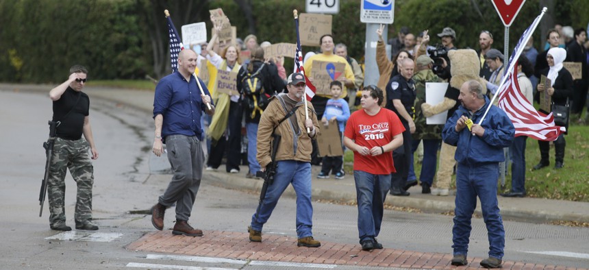 Anti-Muslim protestors cross the street as counter protestors look on in the background outside a mosque in Richardson, Texas, Dec. 12, 2015.