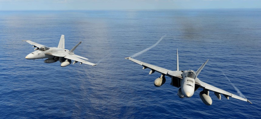Two U.S. Navy F/A-18E Super Hornet participate in an air power demonstration in the Pacific Ocean on April 24, 2013.