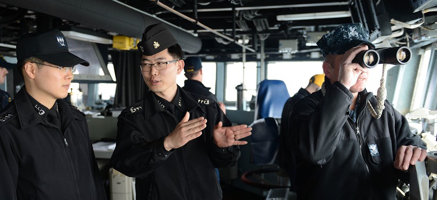 U.S. and Republic of Korea Navy officers inside the guided-missile destroyer USS McCampbell (DDG 85), in waters west of the Korean Peninsula, March 16, 2013. 