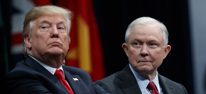 President Donald Trump, left, sits with Attorney General Jeff Sessions during the FBI National Academy graduation ceremony in Quantico, Va., Dec. 15, 2017.
