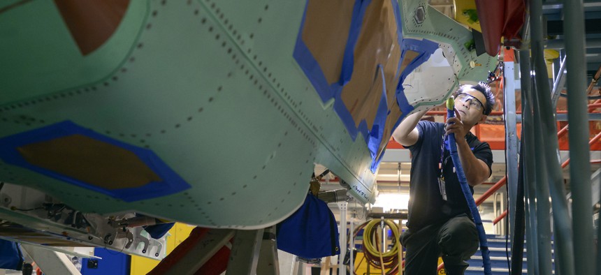 A Northrop Grumman technician puts finishing touches on an F-35 fuselage.