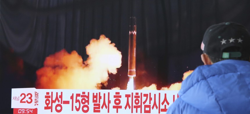 A man watches a TV screen showing what the North Korean government calls the Hwasong-15 intercontinental ballistic missile.