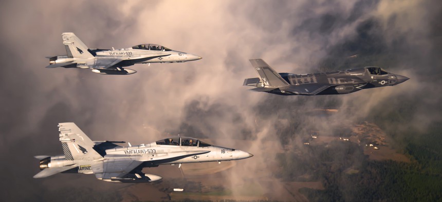 A U.S. Marine Corps F-35 Lightning II aircraft is escorted by two Marine F/A-18 Hornets.