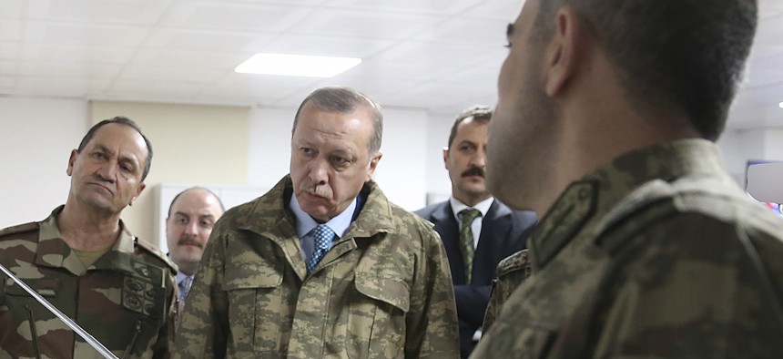 urkey's President Recep Tayyip Erdogan, second left, is briefed by a Turkish Army officer at the command center at the command center in Hatay province, Turkey at the border with Syria, Thursday, Jan. 25, 2018. 