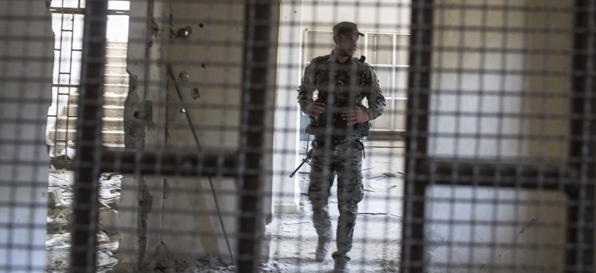 A Syrian Democratic Forces fighter in the liberated soccer stadium-turned-prison where ISIS held locals, Raqqa, Syria, Friday, Oct. 20, 2017. Now, SDF is holding captive 'hundreds' of ISIS foreign fighters. 