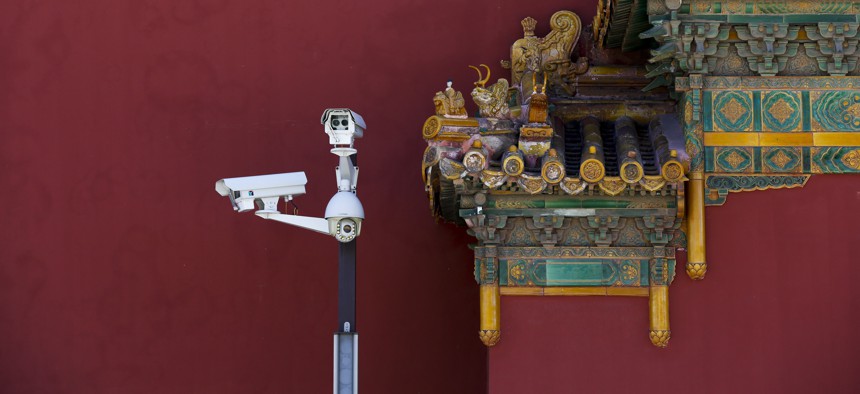Surveillance cameras stand next to the figurines on a main entrance gate of the Imperial Ancestral Temple, or Taimiao next to the Forbidden City in Beijing, Sept. 17, 2017.