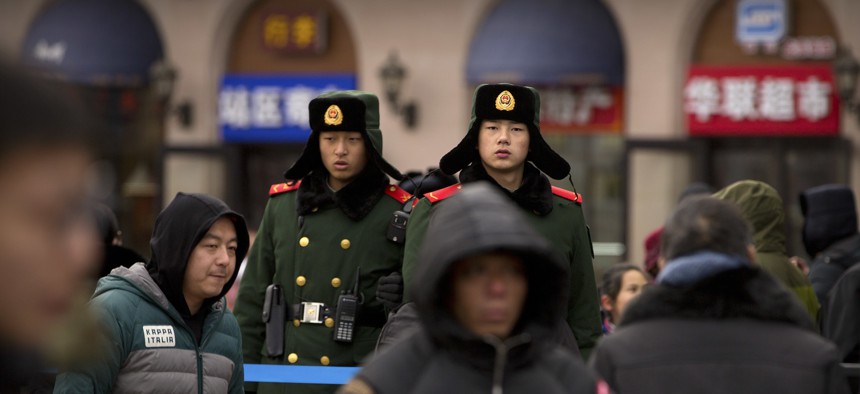 Chinese paramilitary police stand guard outside of the Beijing Railway Station in Beijing, Friday, Feb. 9, 2018.