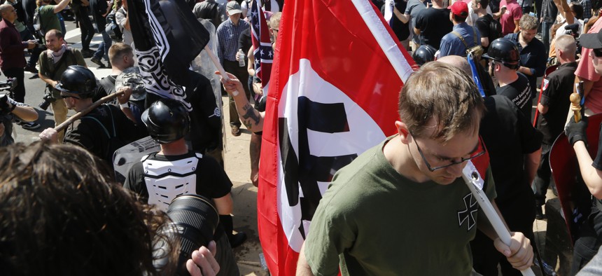 An Aug. 12, 2017, image shows a white supremacist carrying a NAZI flag into the entrance to Emancipation Park in Charlottesville, Va. 