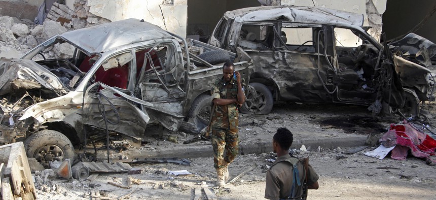 Somali soldiers stand near the wreckage of vehicles in Mogadishu, Somalia, in October, after a car bomb detonated. 