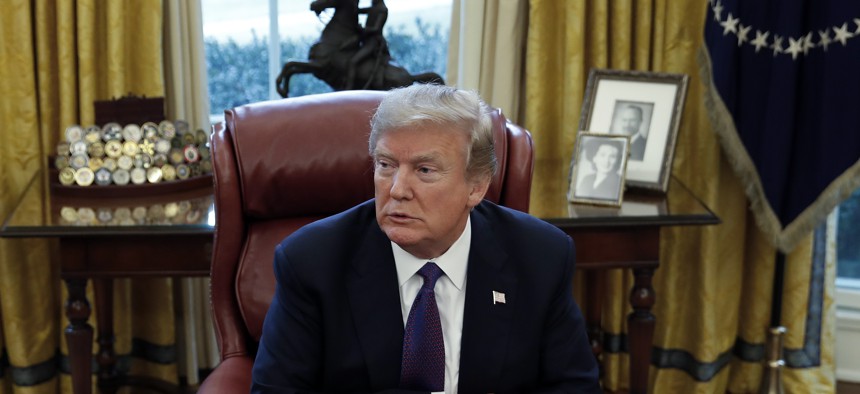 President Donald Trump sits at the Resolute Desk in the Oval Office of the White House in Washington, Jan. 23, 2018.