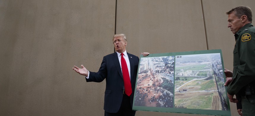 President Donald Trump talks with reporters as he gets a briefing on border wall prototypes, March 13, 2018, in San Diego.
