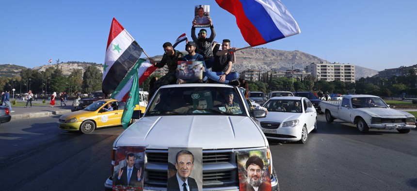 Hundreds of Syrians demonstrated on April 14 in a landmark square in the Syrian capital, waving victory signs and honking their car horns in a show of defiance after U.S.-led airstrikes on their country.