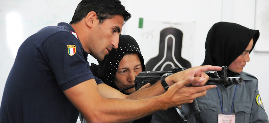An Italian Carabinieri shows a female Afghan National Police recruit how to aim an AMD-65, a Hungarian version of the AK-47, during an eight-week basic police training course at the Central Training Center in Kabul.