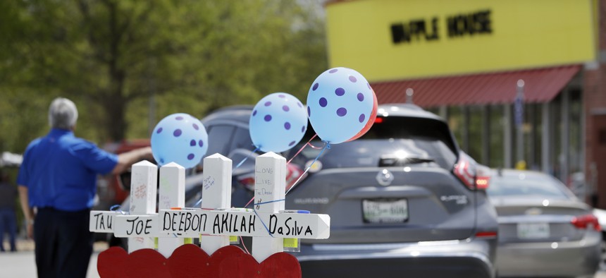 Four wooden crosses stand as a memorial for the four shooting fatalities outside a Waffle House restaurant Wednesday, April 25, 2018, in Nashville, Tenn. 