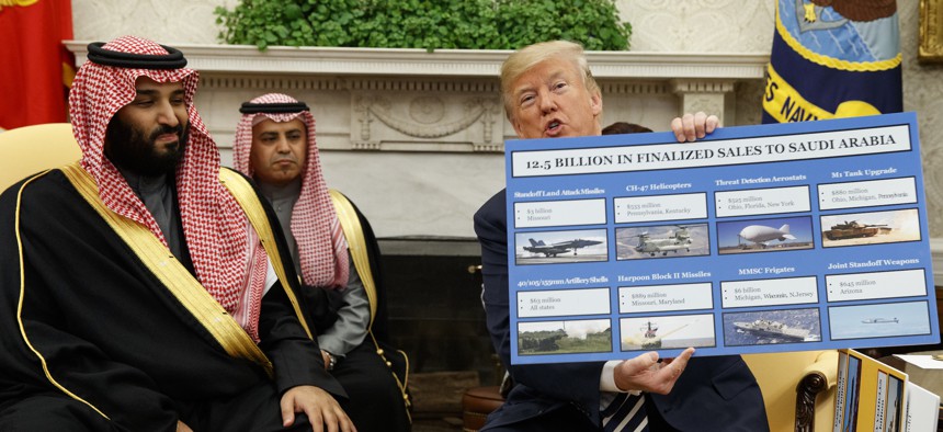 President Donald Trump shows a chart highlighting arms sales to Saudi Arabia during a meeting with Saudi Crown Prince Mohammed bin Salman in the Oval Office of the White House, Tuesday, March 20, 2018, in Washington.