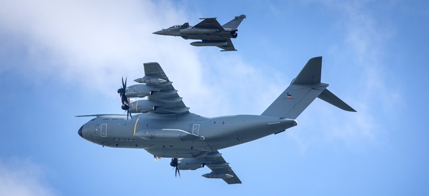 A German Air Force Airbus A400M and two fighter jets during the 2018 International Aerospace Exhibition.