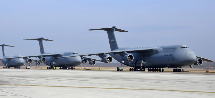 Three U.S. Air Force C-5 Galaxy cargo aircraft sit lined up on the flightline at Westover Air Reserve Base, Mass.