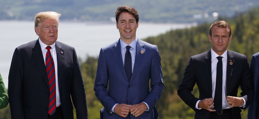 President Donald Trump, Canadian Prime Minister Justin Trudeau, and French President Emmanuel Macron participate in the family photo during the G-7 Summit, Friday, June 8, 2018, in Charlevoix, Canada. 