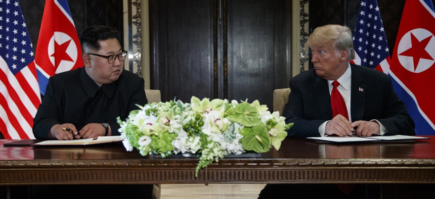 President Donald Trump and North Korean leader Kim Jong Un participate in a signing ceremony during a meeting on Sentosa Island, Tuesday, June 12, 2018, in Singapore.