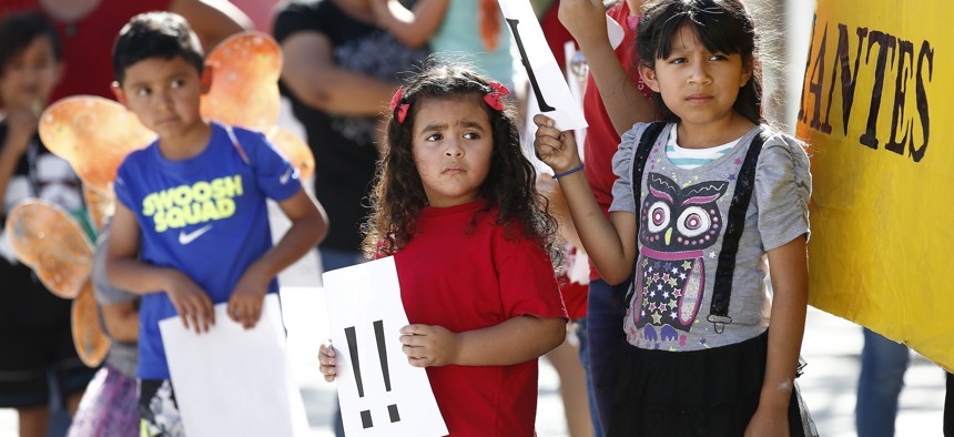 Children listen to speakers during an immigration family separation protest in front of the Sandra Day O'Connor U.S. District Court building, Monday, June 18, 2018, in Phoenix. 