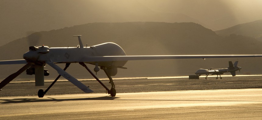 An MQ-1B Predator, left, and an MQ-9 Reaper taxi to the runway in preparation for takeoff June 13, 2014, at Creech Air Force Base, Nev. 