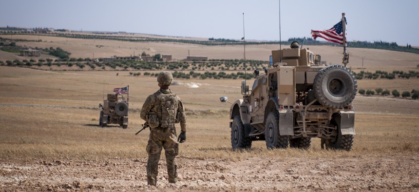 A U.S. Soldier stands guard during a security patrol outside Manbij, Syria, June 24, 2018.