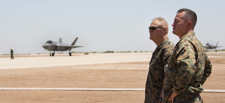 Commandant of the Marine Corps, Gen. Robert B. Neller (left), and Brigadier Gen. Rick Uribe (right), the deputy commanding general of 1st Marine Expeditionary Force, observe an F-35B at Naval Air Station El Centro, California, June 9, 2018.