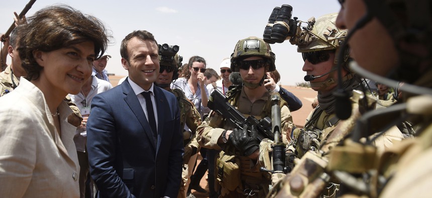 French President Emmanuel Macron, center, and Defense meet soldiers of Operation Barkhane, France's largest overseas military operation, in Gao, northern Mali, Friday, May 19, 2017.