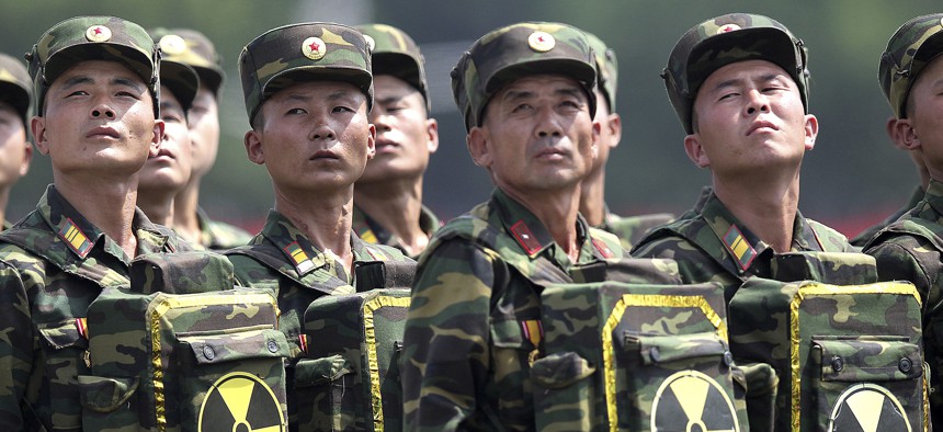In this July 27, 2013 photo, North Korean soldiers turn and look towards their leader Kim Jong Un as they carry packs marked with the nuclear symbol during a ceremony marking the 60th anniversary of the Korean War armistice in Pyongyang, North Korea.