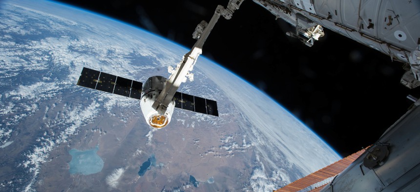 In this 2015 file photo, the Canadarm 2 reaches out to capture the SpaceX Dragon cargo spacecraft for docking to the International Space Station.