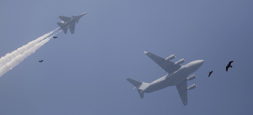 Birds fly past as Indian Air Force Sukhoi fighter jet, left, and Indian Air Force C-17 Globemaster display a fly-by during the rehearsals ahead of annual Republic Day parade in New Delhi, India, Thursday, Jan. 18, 2018.