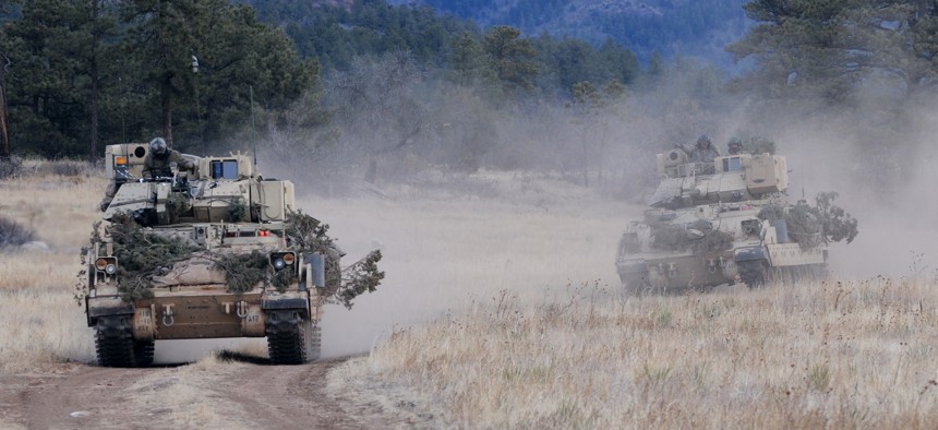 Soldiers from the U.S. Army's 4th Infantry Division drive their M3A3 Bradley Fighting Vehicles to reach a phase line where they will move into a defensive posture during platoon scout training near Fort Carson’s Camp Red Devil, Jan. 26, 2013.