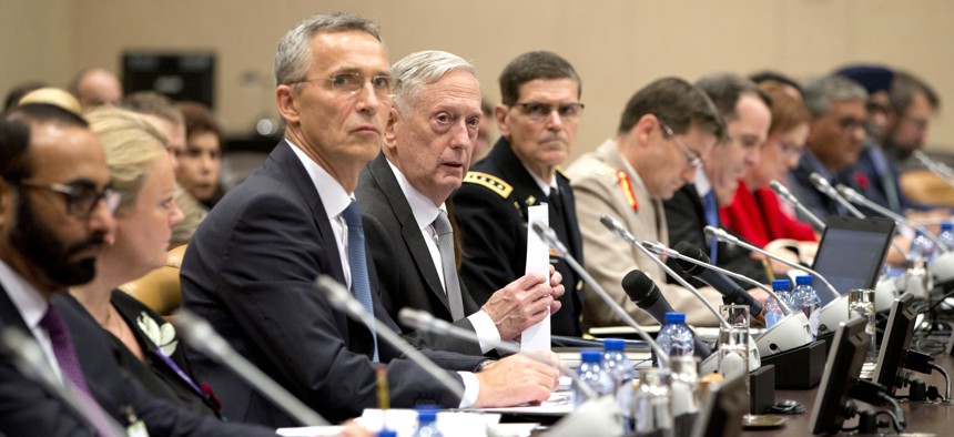 U.S. Secretary for Defense Jim Mattis, center right, and NATO Secretary General Jens Stoltenberg, center left, prepare to make the opening address during a round table meeting of NATO defense ministers and the Coalition to Defeat the Islamic State in 2017