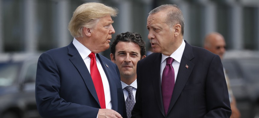  President Donald Trump, left, talks with Turkey's President Recep Tayyip Erdogan, right, as they arrive together for a family photo at a summit of heads of state and government at NATO headquarters in Brussels on Wednesday, July 11, 2018. 