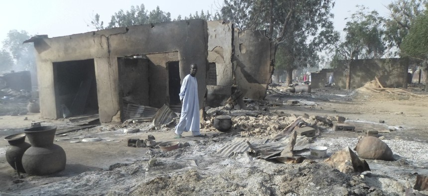In this Sunday Jan. 31, 2016 file photo, a man walks past burnt out houses following an attack by Boko Haram in Dalori village near Maiduguri.