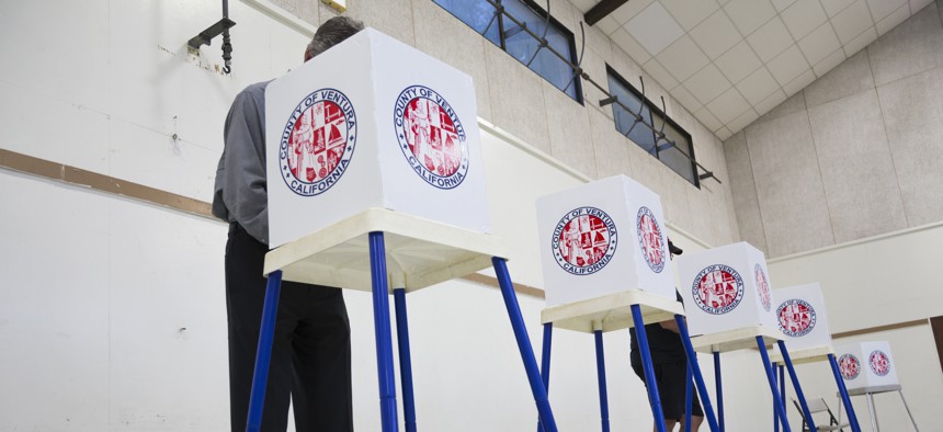 People vote in election booth polling station in a gymnasium in Oak View, California, November 4, 2014.