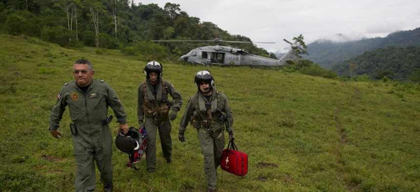Costa Rica Police Air Patrol Officer Capt. George Lozano, left, Naval Air Crewman 3rd Class Joe Wainscott and Chief Naval Air Crewman Justin Crowe head toward a village to assist an injured boy in Bajo, Blay, Costa Rica, during Continuing Promise 2011.