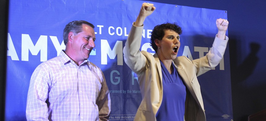 Amy McGrath, right, with her husband, Erik Henderson, pumps her fists after being elected as the Democratic candidate for Kentucky's 6th Congressional District, Tuesday, May 22, 2018, in Richmond, Ky.